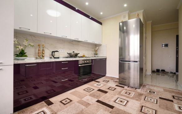 A modular kitchen with purple cabinets and silver appliances